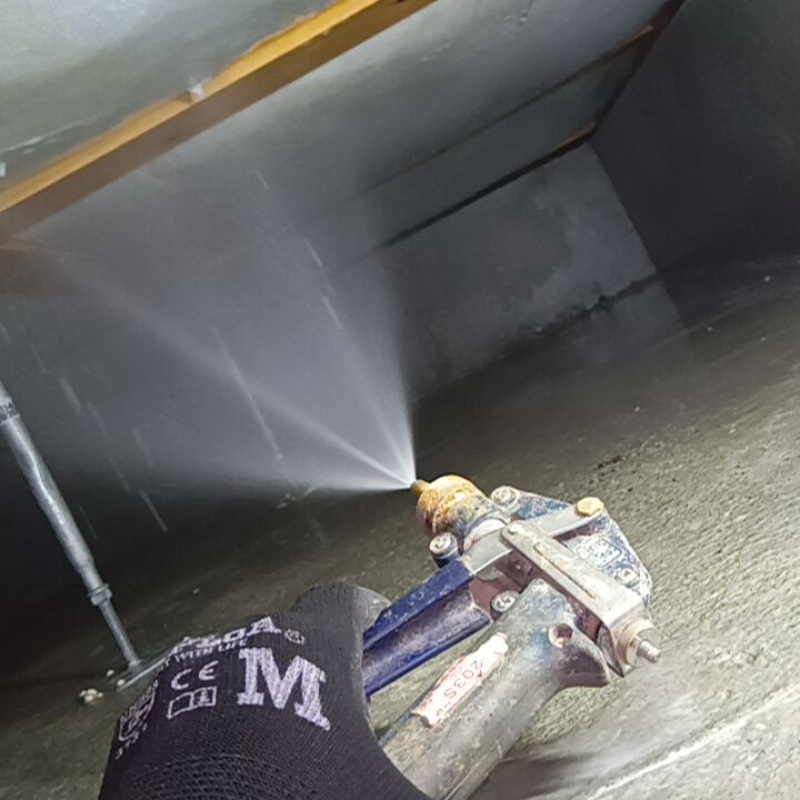 床下木材に防蟻剤を吹きつける様子