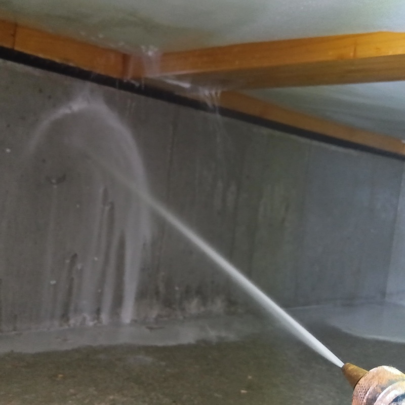 地面に防蟻剤を吹きつける様子