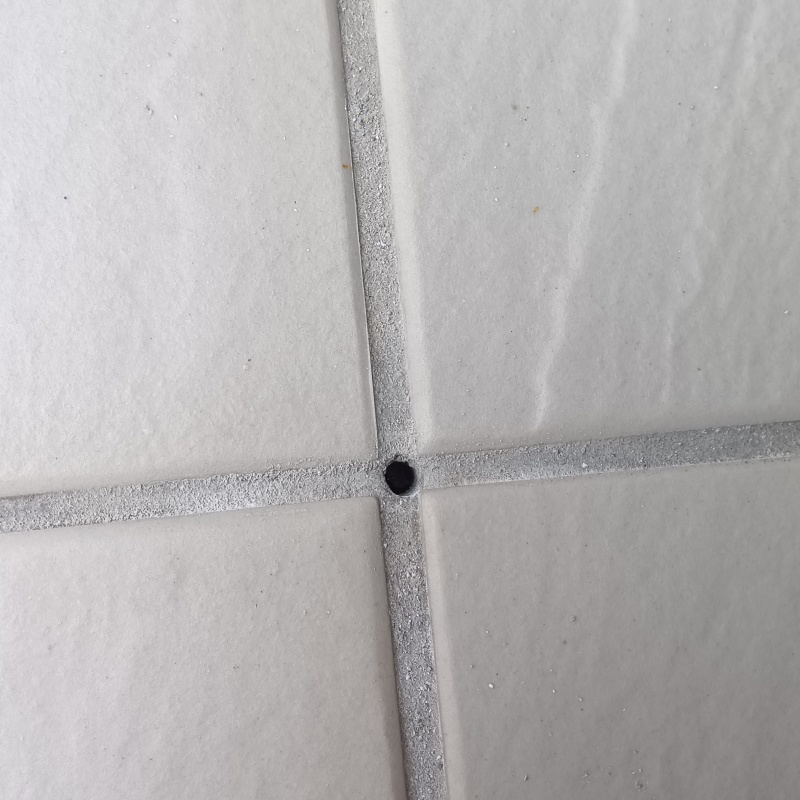 玄関床に防蟻剤を注入する穴を開けている様子