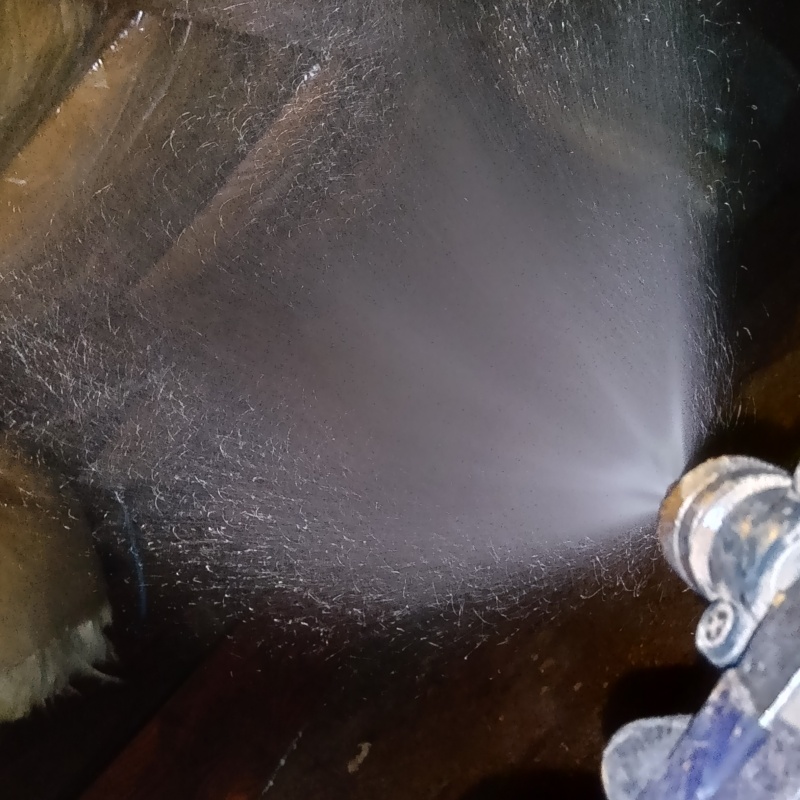 床下木材に防蟻剤を吹きつける様子