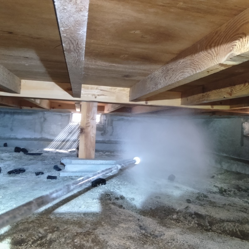 地面にシロアリ駆除剤を散布を吹きつけている様子