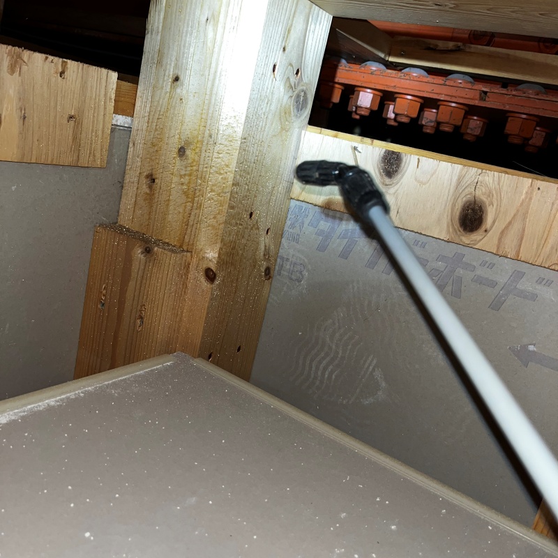 床下木材にシロアリ駆除剤を散布している様子