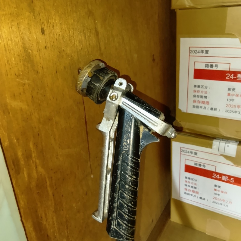 押入れ内部の木製の壁材に穴を開けてシロアリ駆除を注入