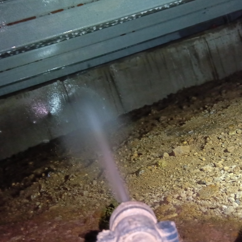 床下の基礎・土壌にシロアリ駆除剤を散布する様子