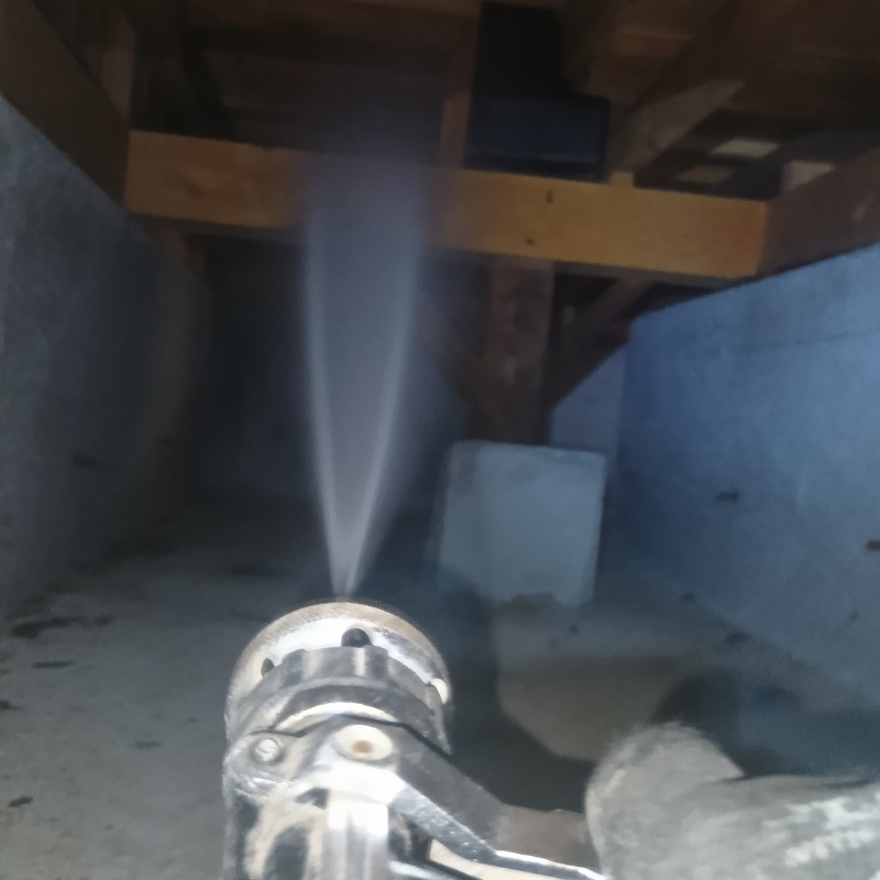 床下木材・大引きにシロアリ駆除剤を散布する様子