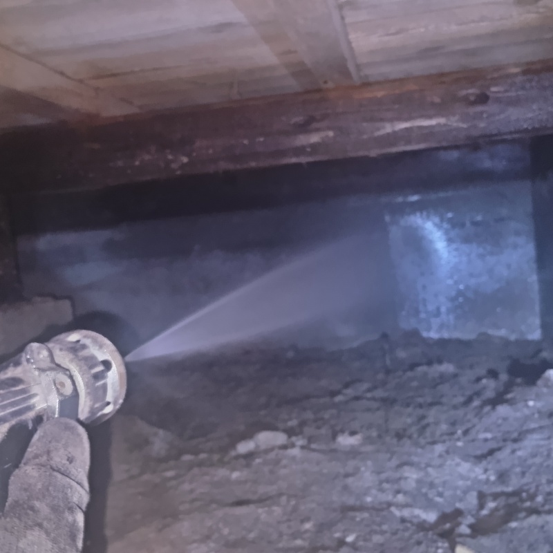 床下の基礎部分にシロアリ駆除剤を散布する様子