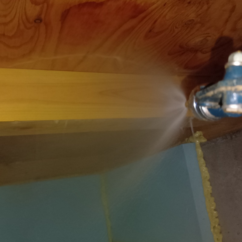 床下木材に防蟻剤を吹きつけている様子