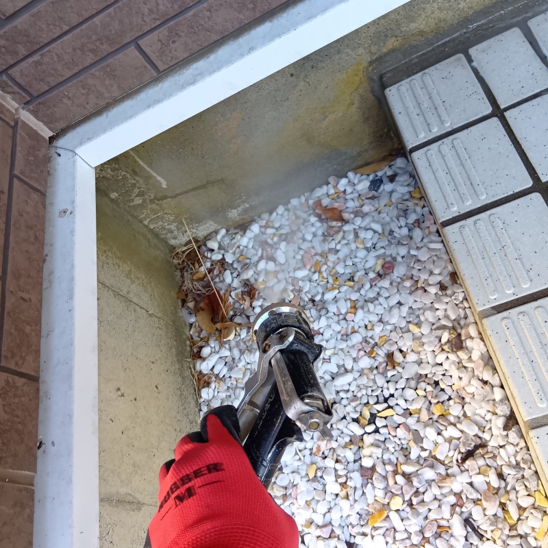 建物外周の砂利にシロアリ駆除剤を散布