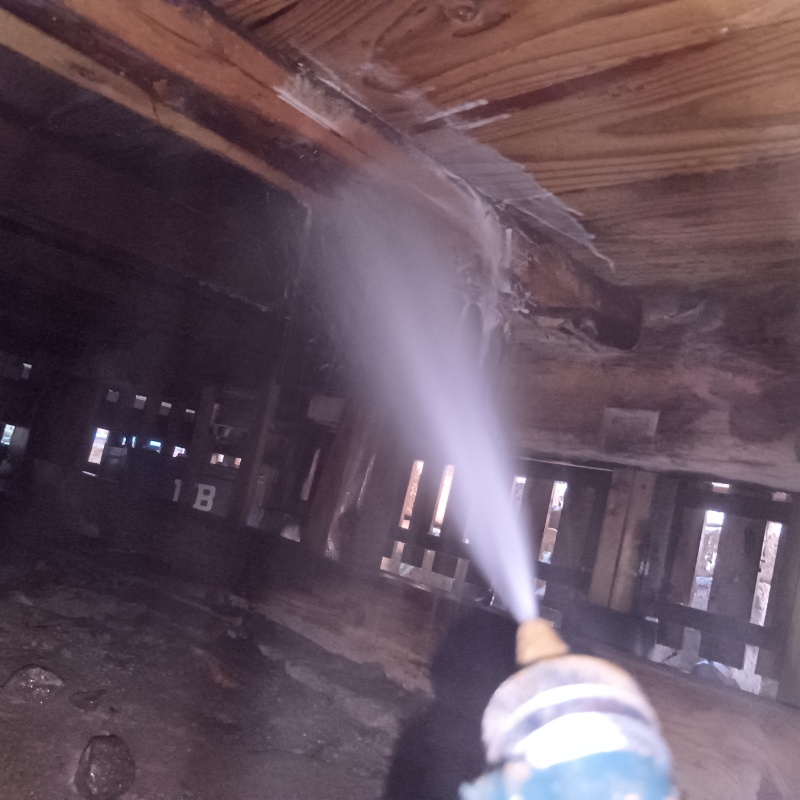 床下の木材にシロアリ駆除剤を散布している様子