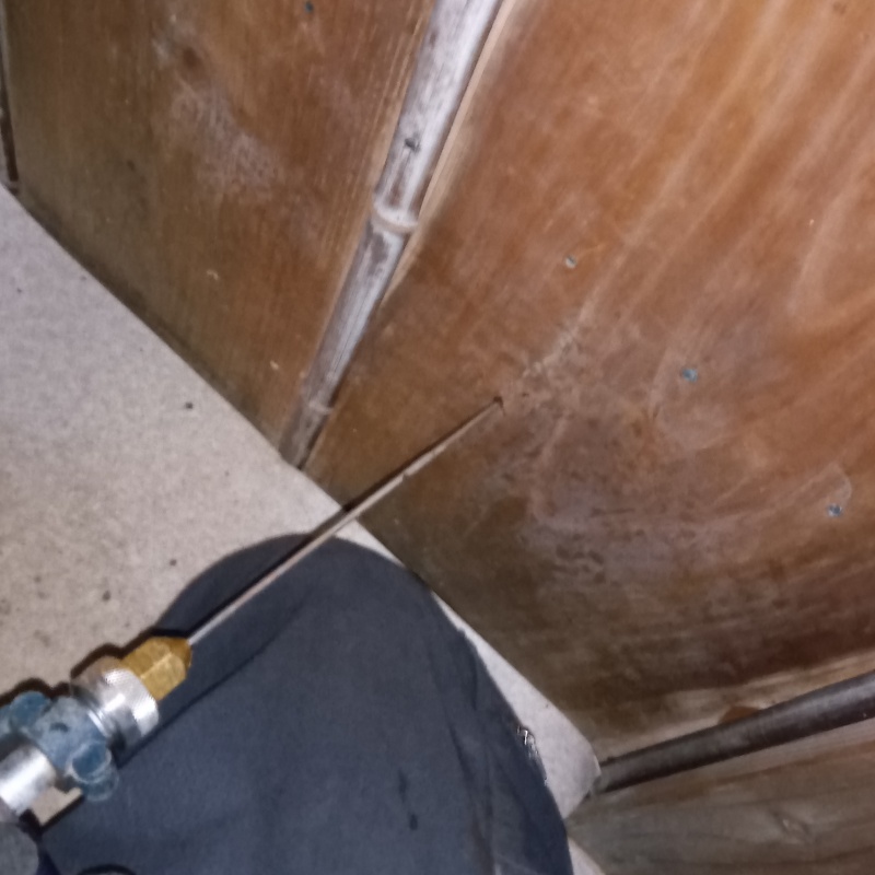 木製の壁に穴を開けてシロアリ駆除剤を注入