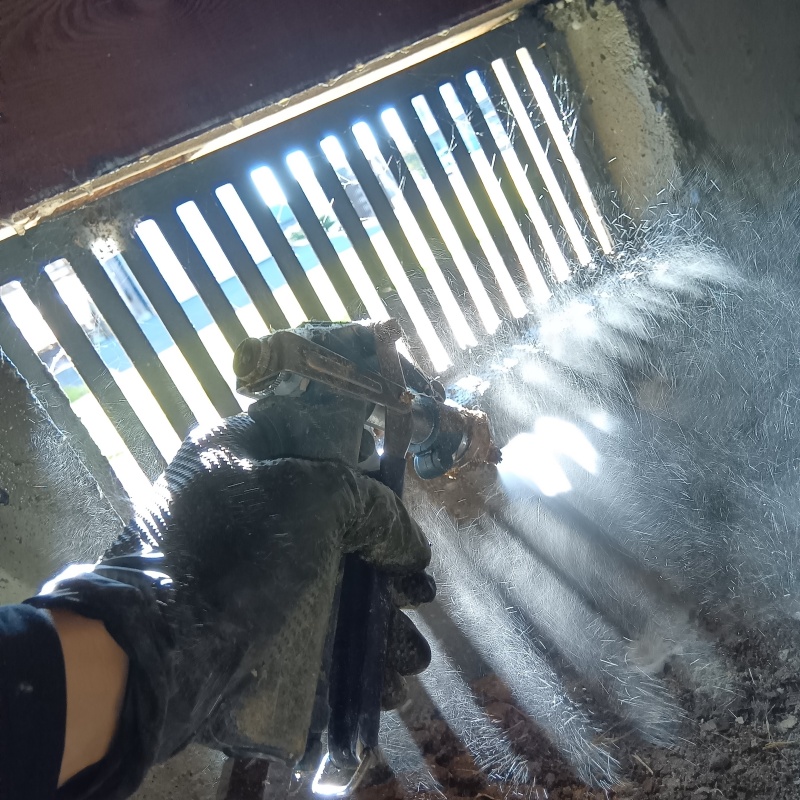 束石にシロアリ駆除剤を吹きつけている様子