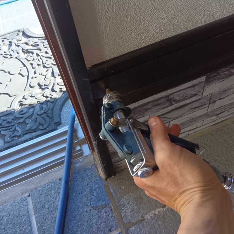 玄関付近の木材に穴を開けてシロアリ駆除剤を注入