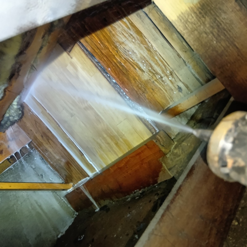 床下の木材にシロアリ駆除剤を散布している様子