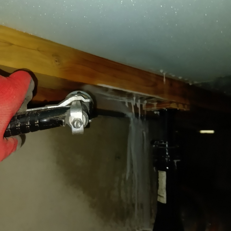 床下の木材部分に防蟻剤を吹き付けている様子