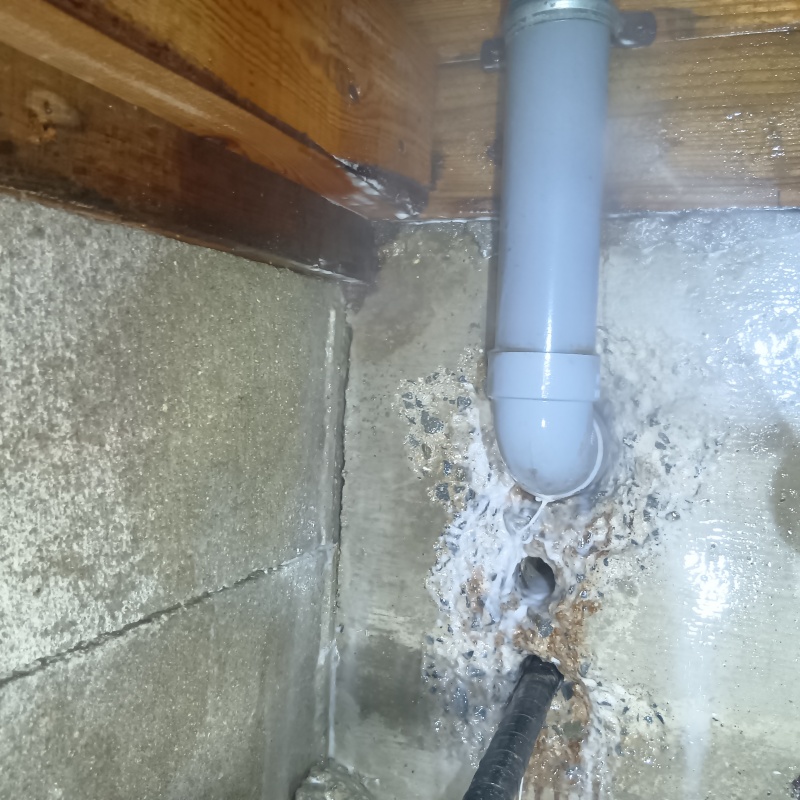 配管まわりにシロアリ駆除剤を吹き付けている様子