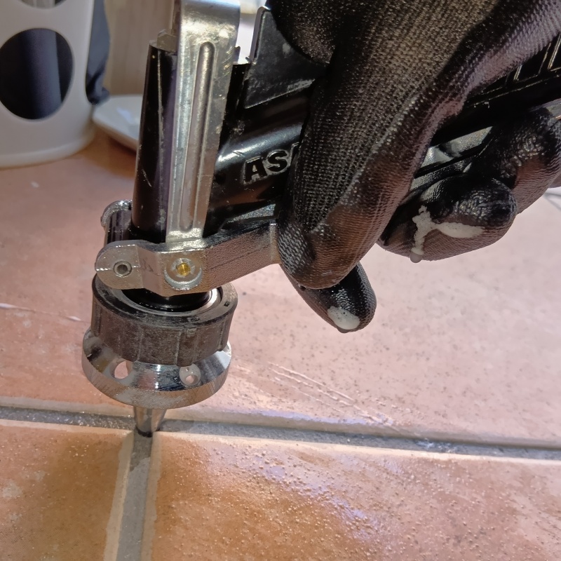 床に穴を開けて防蟻剤を注入している様子