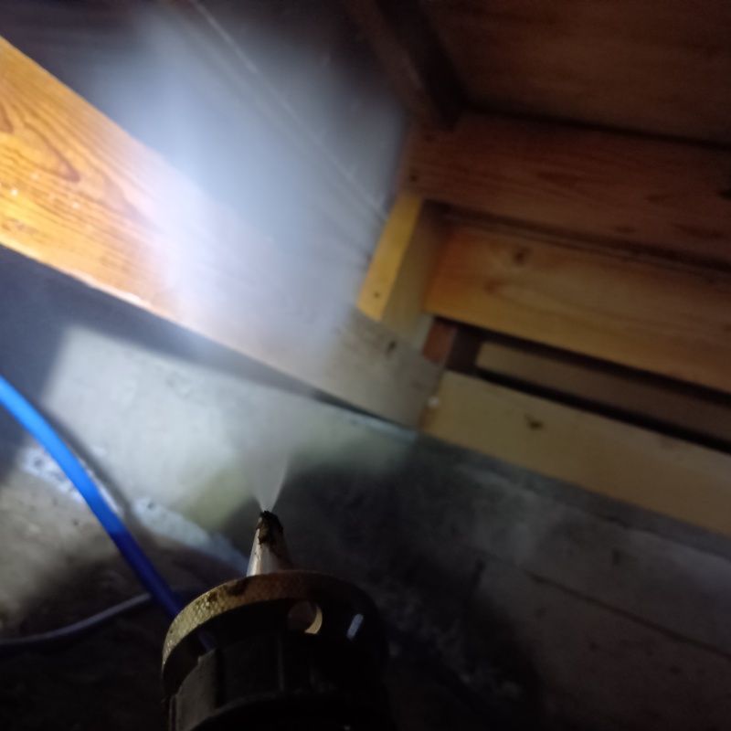 木製の床束に防蟻剤を吹き付けている様子