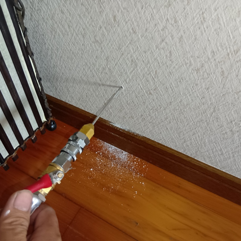 壁内にシロアリ駆除剤を注入している様子