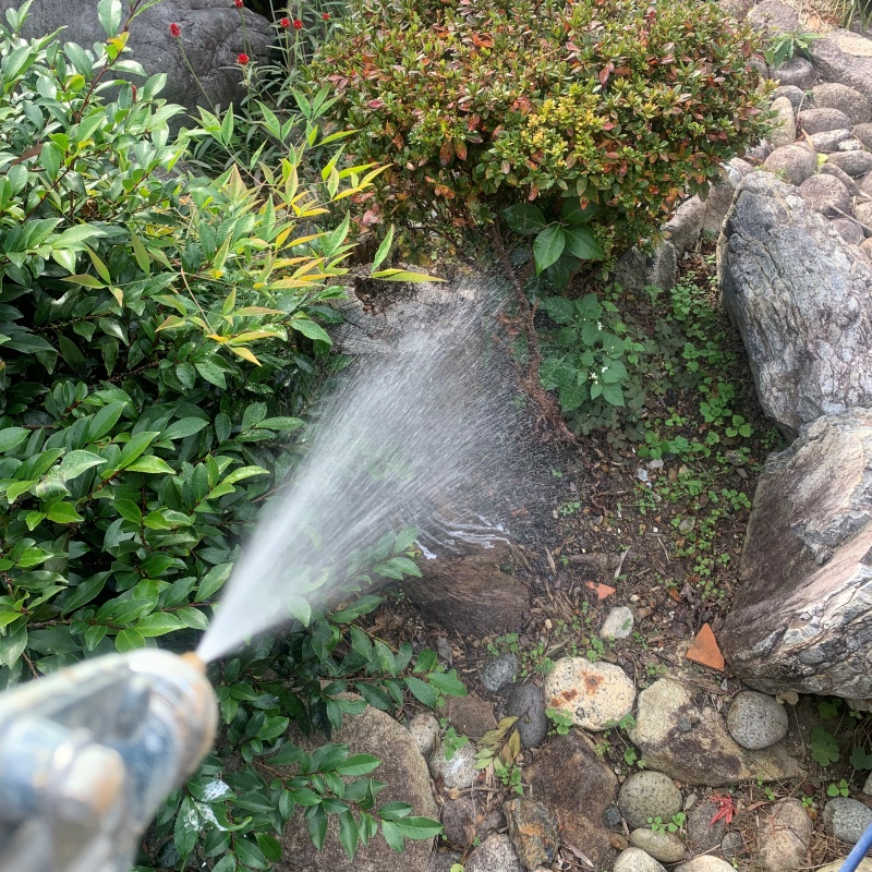 建物外周の土壌に薬剤を吹きつけている様子