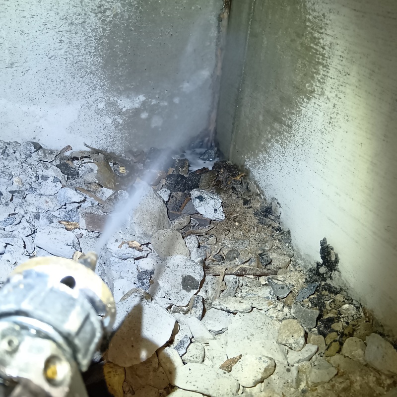 床下の地面にシロアリ駆除剤を吹きつけている様子