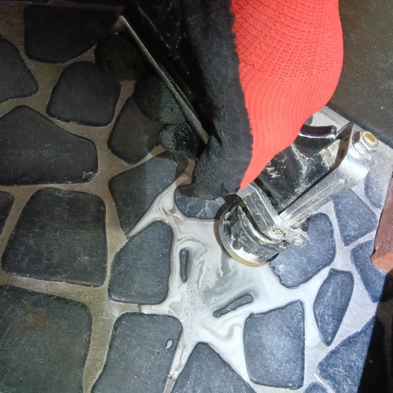 目地からシロアリ駆除剤を注入している様子