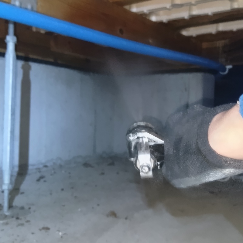 木材とコンクリートのすき間にシロアリ駆除剤を散布