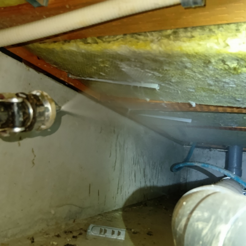 床下断熱材にシロアリ駆除剤を散布する様子