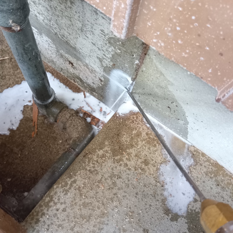 建物外周にシロアリ駆除剤を吹きつけている様子