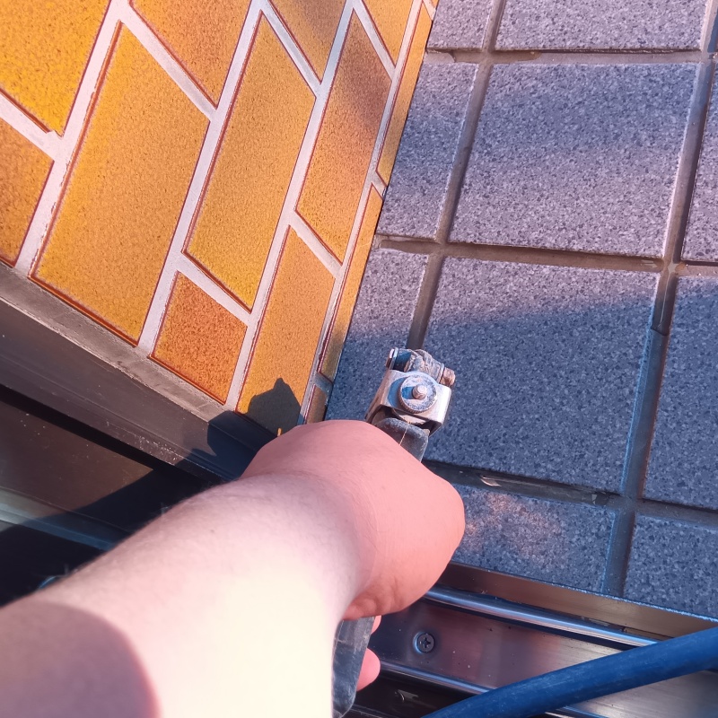 目地に穴を開けてシロアリ駆除剤を注入している様子