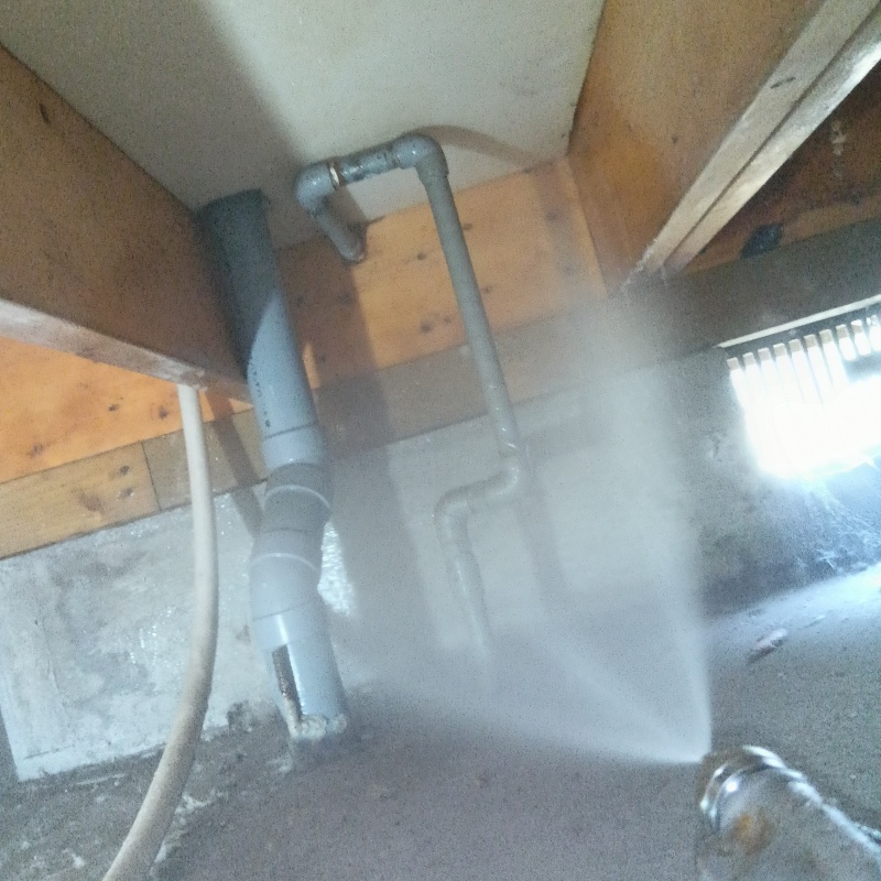 配管まわりの木材に防蟻剤を吹き付ける様子