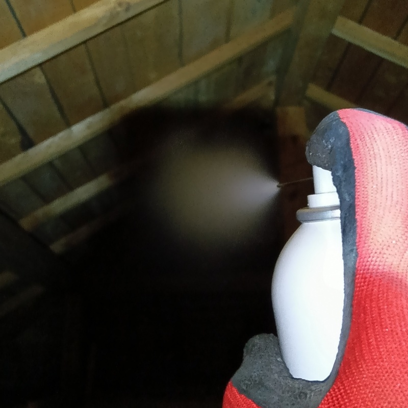 屋根裏に忌避剤を散布する様子
