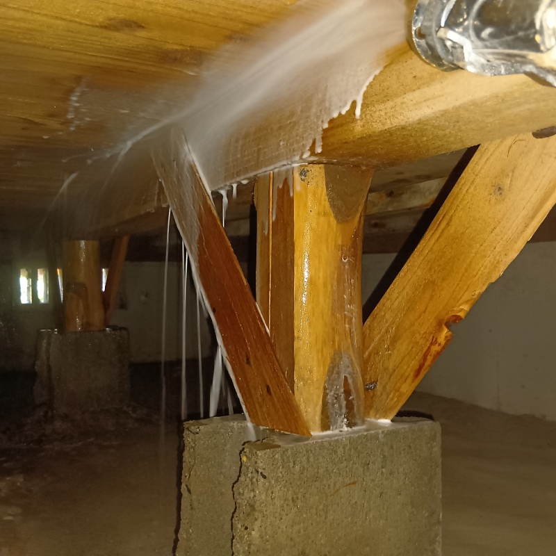 床下木材にシロアリ駆除剤を散布する様子