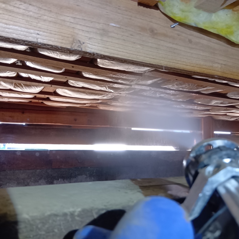 床下断熱材にシロアリ駆除剤を散布する様子