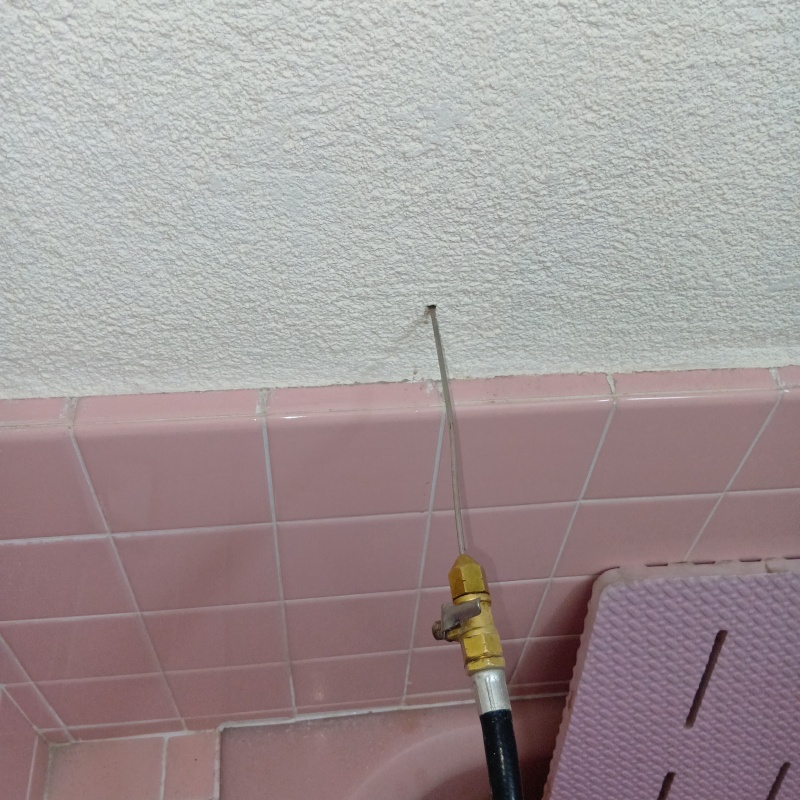 浴室の壁に穴を開けてシロアリ駆除剤を注入