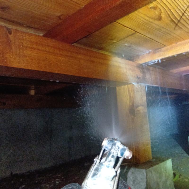 床束にシロアリ駆除剤を散布する様子