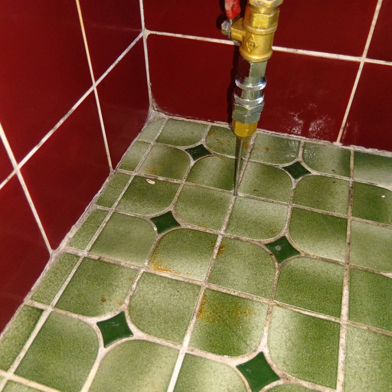 玄関先のタイルの目地からシロアリ駆除剤を注入