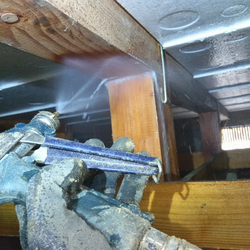 床下木材にシロアリ駆除剤を散布する様子