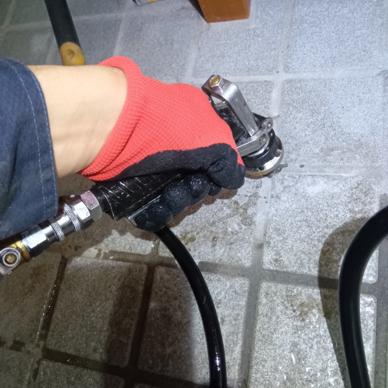 玄関床の目地からシロアリ駆除剤を注入している様子