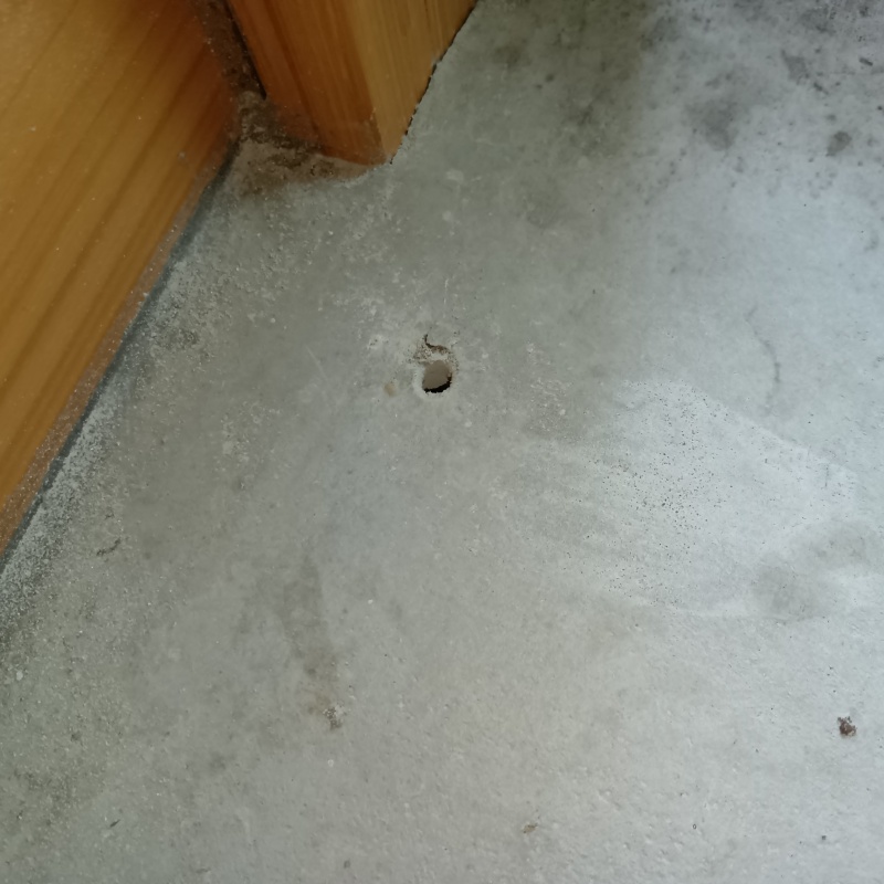 玄関床のコンクリートに穴を開けた様子
