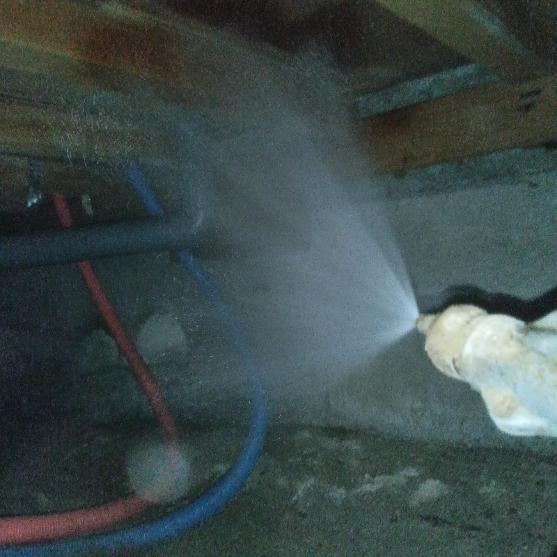 床下木材にシロアリ駆除剤を散布する様子