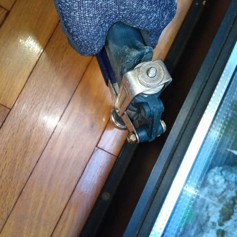 窓枠近くの床材に穴を開けてシロアリ駆除剤を注入