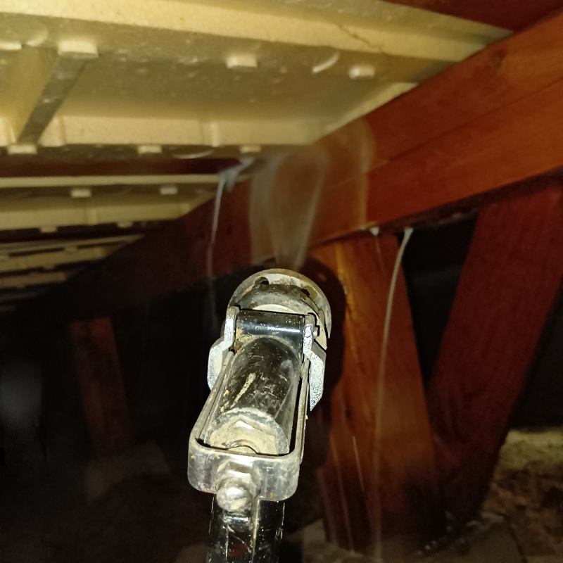 床下断熱材にシロアリ駆除剤を散布する様子