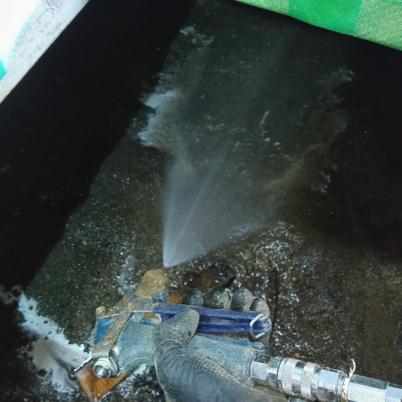 床下の土壌にシロアリ駆除剤を散布する様子