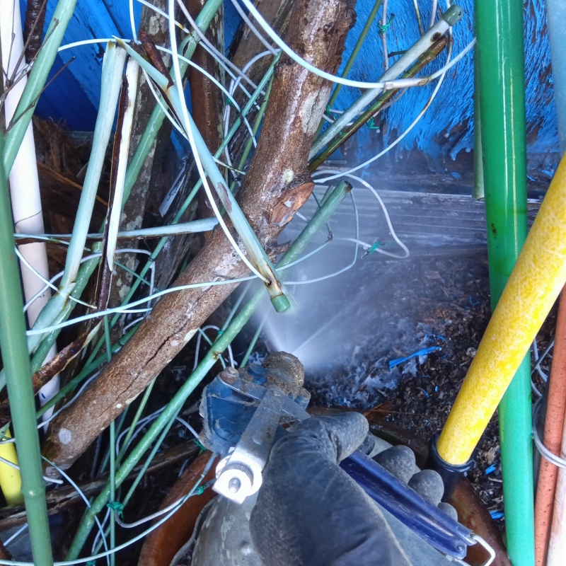 建物外周の土壌にシロアリ駆除剤を吹き付ける様子