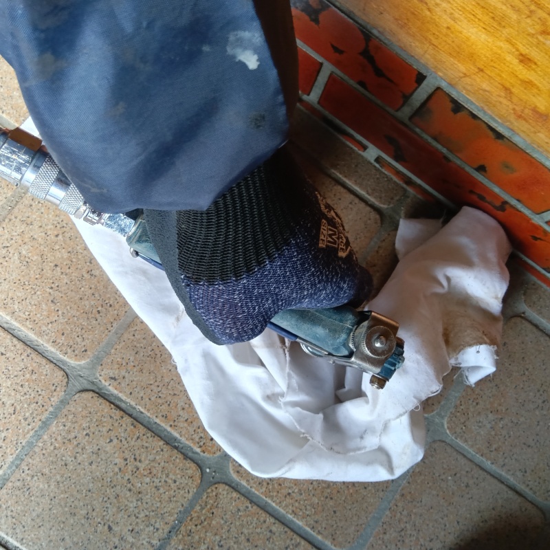 玄関床にシロアリ駆除剤を注入している様子