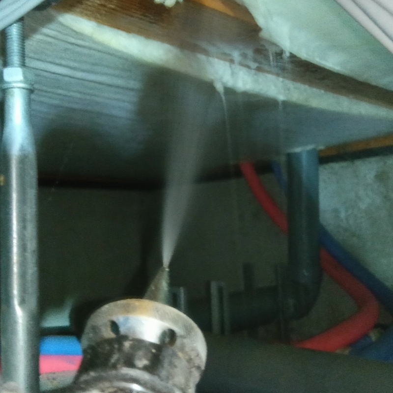 床下断熱材に防蟻剤を吹き付ける様子