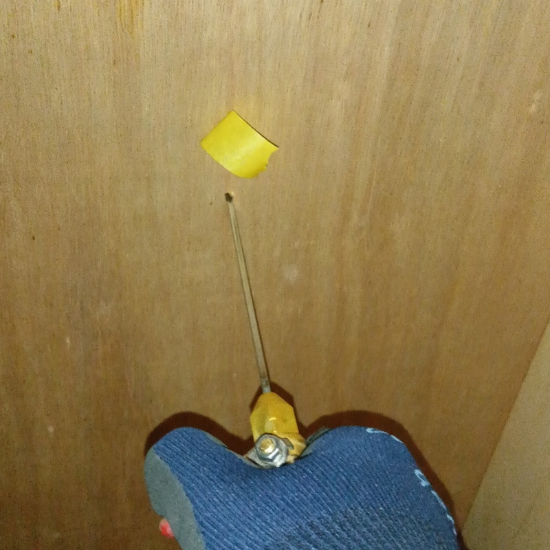 壁に開けた穴からシロアリ駆除剤を注入する様子