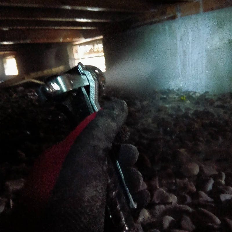 床下の基礎部分にシロアリ駆除剤を散布する様子