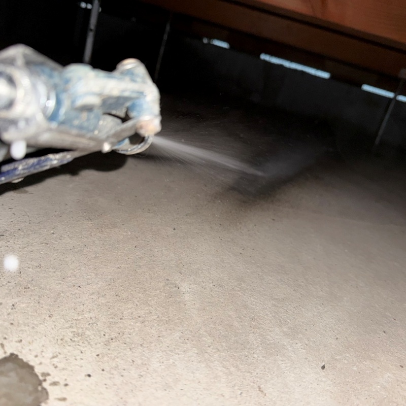 地面に防蟻剤を吹きつけている様子