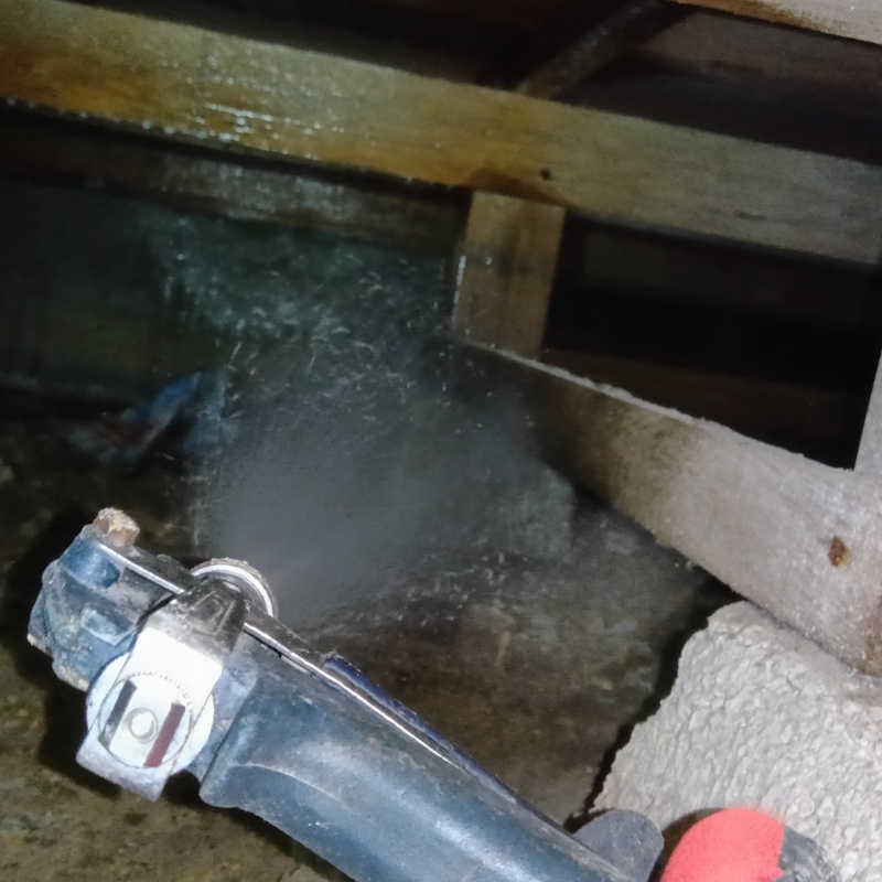 束石にシロアリ駆除剤を吹きつけている様子